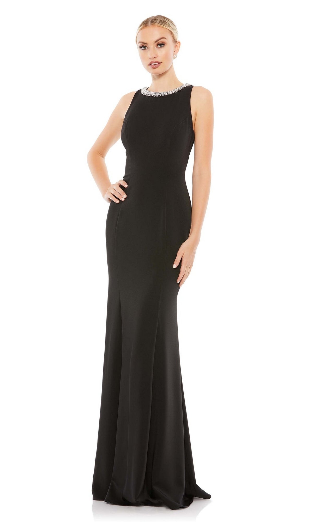 A woman poses with one hand on her hip against a plain white background, wearing the Mac Duggal 49093 Beaded-Neck Long Prom Dress—a sleeveless, floor-length black evening gown featuring an embellished neckline.